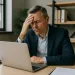 Concerned business leader reading an email, illustrating the impact of poor communication, unclear escalation, and low team accountability.